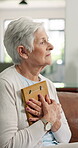 Sad, thinking and old woman with photo frame for grief, nostalgic memory or lonely in retirement. Loss, emotional elderly person and hug photograph in home for mourning, broken heart and bereavement