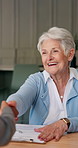 Senior, woman and handshake in home with document, life insurance or contract for asset management. Elderly person, consultant and shaking hands in house with paperwork, retirement planning or policy