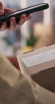 Phone, delivery and person in home with box for order confirmation with ecommerce sticker. Cellphone, picture and hands of customer with cardboard package for cargo shipping verification in apartment