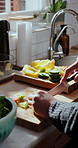 Cooking, hands and man in kitchen, cutting vegetables and prep for vegetarian meal, salad and nutrition. Organic recipe, wooden board or person in home, above or healthy food for vegan diet and knife