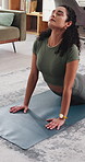 Woman, home and yoga for zen workout, spiritual wellness or cobra pose on floor mat in lounge Yogi, stretching or arching back for pilates, exercise or person with mental wellbeing and stress relief