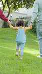 Back, parents and holding hands with child outdoor for travel, love and bonding together. People, walking or kid with parental support, morning journey and fresh air for family connection in backyard