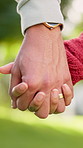 Holding hands, nature and couple on date with marriage, bonding and care outdoor together with loyalty. Love, commitment and man with woman for connection or trust in relationship on anniversary.