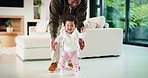 Smile, baby and walking with father in home for first steps, balance support and proud moment. Excited, man and helping toddler for mobility guidance, teaching coordination or milestone encouragement