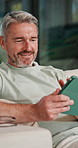 Scroll, online and man with tablet in house, relax and reading ebook on web or comfortable on couch. Browse, novel and mature person with tech for entertainment, happy and chill with app subscription