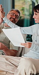 Couple, documents and high five in home for insurance, savings or investment growth on sofa. Happy, success and mature woman with man for support in financial planning, asset management or budget