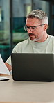 Mature, man and documents with laptop in home for finance, budget planning or tax deduction. Male person, remote work or computer with paperwork or invoices for financial audit or expenses in house