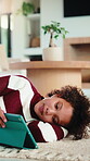 Child, reading and relax with tablet in house, elearning or skill development with assignment on web. Online education, kid and girl with tech for knowledge, research and digital activity in home