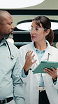 Medical, team and talk in hospital with tablet, online research and consulting for patient diagnosis. Mature people, healthcare worker and collaboration with tech, conversation and wave to coworker.