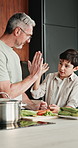Dad, vegetables and high five with child in kitchen for meal prep, healthy diet or cooking lunch. Father, kid or son learning with natural ingredients for culinary lesson or hospitality in home