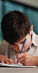 Kid, student and writing in notebook at house for education, studying and exam preparation. Boy, child or pupil with stationery for learning, school homework and quiz assignment for knowledge in home