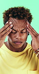 Tired man, headache or stress in studio with injury, burnout or anxiety with fatigue or brain fog. Male person, African model or pain with migraine for mental health or pressure on green background