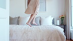 Holiday, fun and legs on bed with jump, travel optimism and happiness on summer getaway. Tourist, trip or female person in hotel room with good time, vacation enjoyment or playful energy in bedroom.