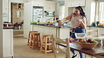 Woman, fun and dancing with energy in kitchen, meal prep and kick movement on weekend or celebration .Happy person, singing and stress free with rhythm, cooking and   active for achievement in house