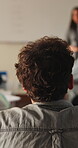 College, student and listening to lesson in classroom, education and teacher with assignment advice. Back, learner and person with knowledge, discussion and explanation for exam or learning in school