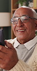 Reading, phone and senior man in home, word game app or online brain teaser for retirement wellness. Happy, crossword puzzle or old person with mobile for laugh, play memory activity or entertainment