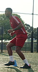 Man, running and soccer player with cone for training, exercise or practice for competition outdoor. Athlete, person or footballer on field with cardio workout, sports drill or equipment for fitness.