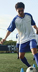 Man, running and soccer ball with cone for fitness, training and team outdoor for competition practice. Series, person and football player on field with sports drill, skill development and equipment.