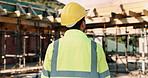 Thinking, construction site and back of man in city for urban planning, building project and repair. Civil engineering, helmet and person with reflection, ideas and ppe for safety in infrastructure