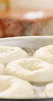 Baker, pot and oil in kitchen with doughnuts, cooking and small business with pastry. Patisserie, person and quality control for catering, restaurant industry and production for breakfast or snack