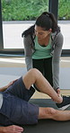 Physiotherapy, personal trainer and man in home with stretching, muscle recovery and fitness. Active, person or coach in house with support for physio exercise, healing knee injury and joint pain