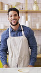 Happy man, face or barista serving with coffee in cafe for hospitality, catering or customer service. Portrait, male person or espresso artist with smile, latte or cappuccino cup on counter in shop