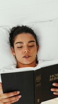 Woman, reading and relax on bed with bible, above and pillow for faith, story or comfort in house. Girl, book and religion with scripture, cozy and chill with Christian text in morning at apartment