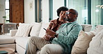 Watching tv, home and couple with remote on sofa, entertainment or relax with partner in living room. Happy, mature man and bonding with African woman in lounge, streaming movie and change channel
