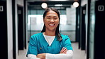 Healthcare, face and nurse with arms crossed in clinic for medical service, trust or about us pride. Professional, asian woman or happy in hospital hallway for health support, integrity or confidence
