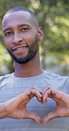 Fitness, runner and happy man with heart hands for love health or wellness in outdoor park. Active, male person or smile with like emoji or shape for healthcare, stamina or endurance in nature