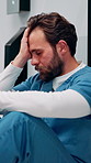 Stress, hallway and doctor with mistake in hospital for patient loss, surgery fail and crisis. Healthcare, thinking and man with worry, guilt and regret on floor for medical service, burnout or error