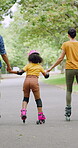 Rollerskate, family and holding hands with child for outdoor fun, learning and support in park. Back, parents or people with kid for practice, teaching and hobby together on holiday or weekend