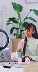 Influencer, smile and wave with laptop for streaming, follower interaction and content creation. Woman, tech and ring light in home for subscriber engagement, introduction and review in living room