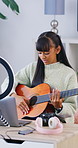 Girl, guitar and influencer with laptop, live stream or recording video for content creation. Person, tech and teenager with ring light, teaching instrument and music tutorial on social network