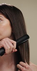 Routine, haircare and woman with iron for heat, equipment or straight hair for texture or getting ready. Studio background, grooming and person with product for hairstyle, straightener or beauty tool