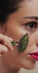 Woman, skincare and jade roller in studio for wellness, blood circulation or reduce puffiness. Dermatology, face and girl with stone tool for massage, tighten pores or natural skin glow in closeup