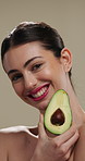 Face, woman and skincare with avocado for beauty, vitamin c and brighten skin in studio background. Portrait, person and fruit for organic cosmetics, facial hydration and antioxidants for self care