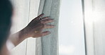 Woman, hand and curtain in home by window, morning routine and sunlight to start day on weekend break. Female person, open drapes and wake up in apartment to check weather, sunshine or getting ready.