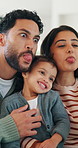 Parents, girl and smile with funny face, playful and laughing with comic joke and happy in home. Father, mother and daughter with bonding, memory and support together for weekend in living room
