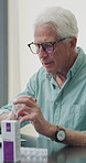 Senior man, medication and video call in home for advice, information or dosage instruction. Elderly patient, telehealth and technology with medicine or tablets in house with glasses in retirement