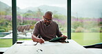 Tablet, document and mature man with home bills, accounting or financial report. Writing, planning and black person with paperwork, digital app and calculation for expenses, budget or savings