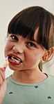 Toothpaste, oral health and face of child in bathroom for self care, wellness and clean mouth. Happy, dental hygiene and portrait of girl brushing teeth for morning routine with fresh breath in home.