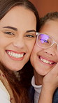 Mom, child and happy face with hug for love, childhood care or embrace together in home. Portrait, mother and daughter with kid, smile or glasses for family time, bonding or affection in house