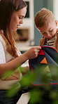 Mother, child and packing in home with backpack, assistance and getting ready for preschool education. Woman, son and help in house with bag, morning routine and preparation for learning development.