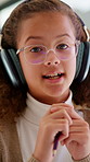 Girl, face and video call with headphones for online lesson, virtual class or assessment in home. Portrait, child or kid talking with glasses in POV for education, elearning or communication in house