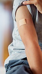 Person, arm and child with plaster for vaccination, flu shot or medical immune booster in hospital. Kid, bandage or injection with vaccine for healthcare, immunity or health protection in clinic