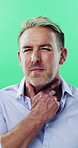 Face, man and itchy neck in studio with rash, skin irritation and allergic reaction. Sick, mature person and scratch throat with cough, dermatitis inflammation and chronic eczema on green background