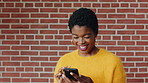 Laugh, black woman and student with phone by brick wall for networking, social media or email for college. Happy, tech and person with cellphone for texting or feedback on university application.