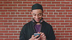 Smile, man and student with phone by brick wall for networking, social media or email for college. Happy, tech and male person with cellphone for texting or feedback on university application.