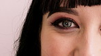 Eyes, makeup and face of woman in studio for beauty, cosmetics and makeover with mascara. Cosmetology, portrait and closeup of person with eyeshadow, eyeliner and products on white background